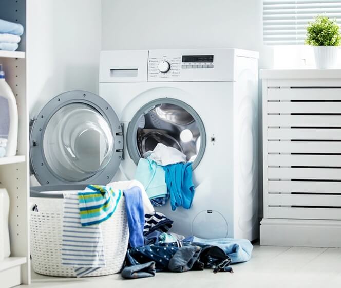 洗衣籃裡的衣服準備擺進滾筒式洗衣機清洗