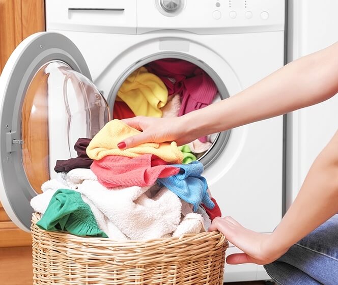洗衣籃和滾筒洗衣機中堆滿了各種色彩鮮艷的衣物